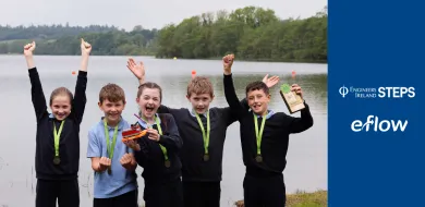The image shows a group of school students with a prize. There are two logos on the side, eFlow and Engineer Ireland STEPS.